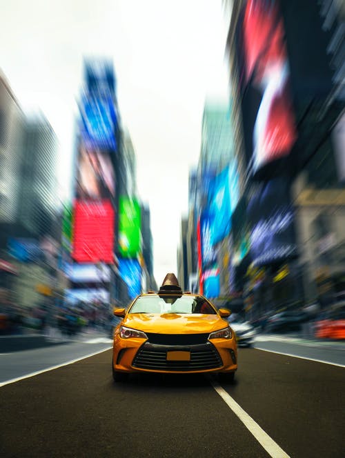 道路上的黄色出租车的选择性照片 · 免费素材图片
