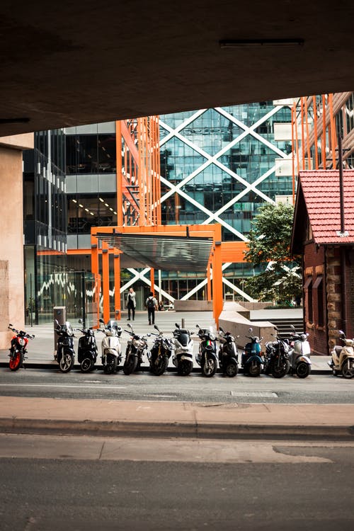 摩托车停在建筑物旁边 · 免费素材图片