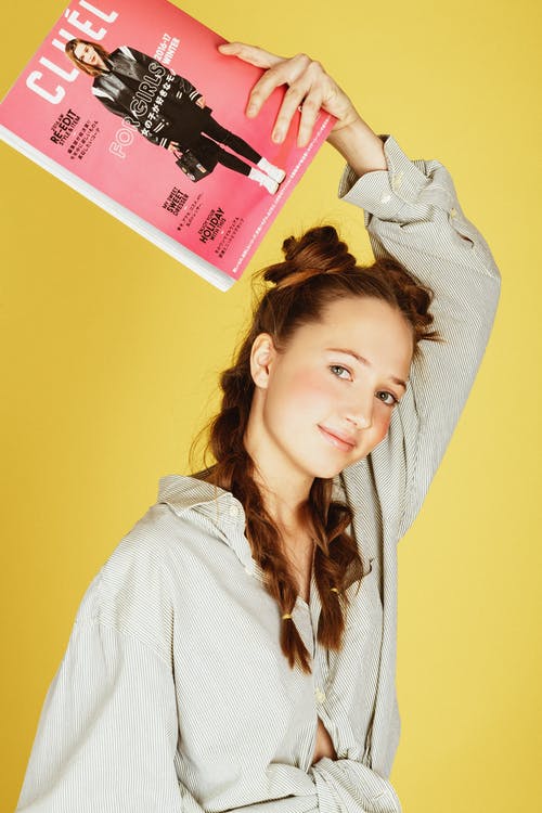 女人抱着杂志的照片 · 免费素材图片