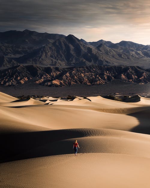 在沙漠上行走的女人的照片 · 免费素材图片