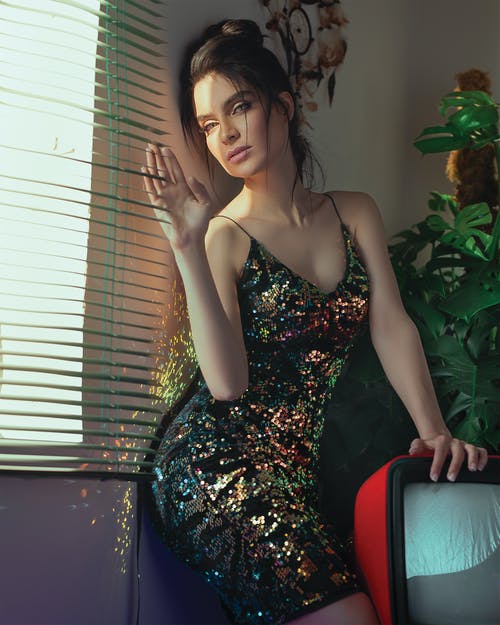 靠在窗户旁边的墙上的女人的照片 · 免费素材图片