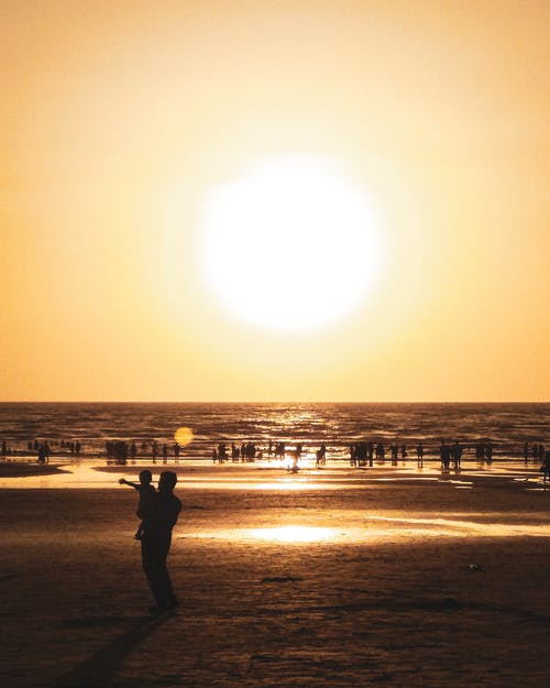 黄金时段海滩上人的剪影摄影 · 免费素材图片