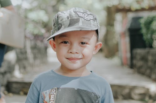 迷彩帽的微笑男孩的选择性焦点肖像照片 · 免费素材图片