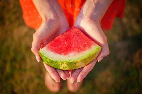 人类手掌上的红色西瓜果实的特写摄影 · 免费素材图片