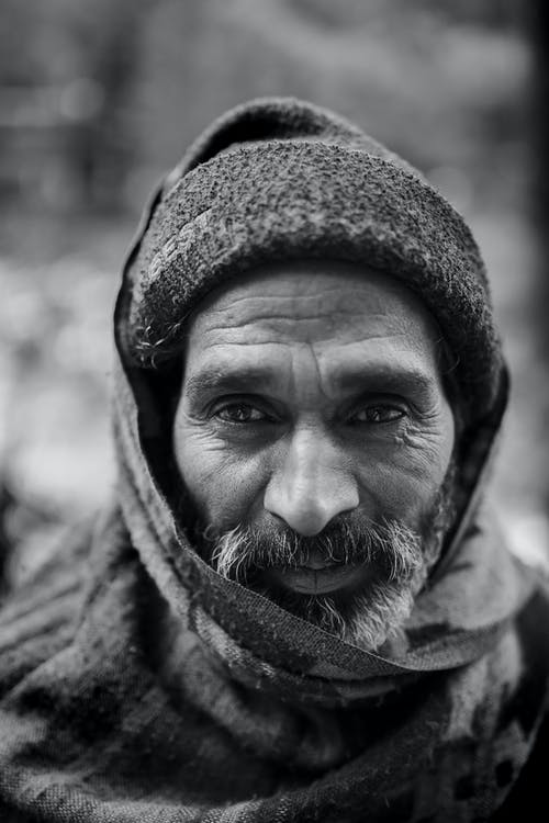 老人在豆豆和围巾在他头上的选择性焦点灰度肖像照片 · 免费素材图片