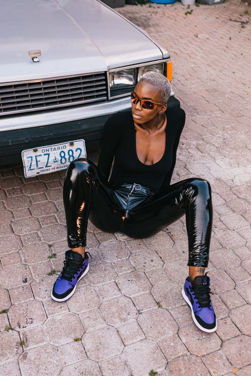 坐在停放的汽车前的黑色勺领长袖衬衫的女人 · 免费素材图片