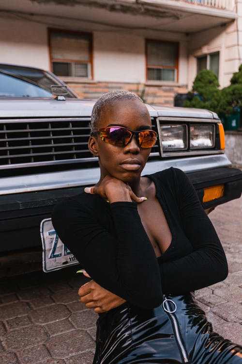 黑色的v领上衣，坐在车前坐着的女人 · 免费素材图片