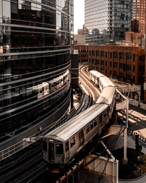 玻璃大楼旁边的灰桥火车照片 · 免费素材图片
