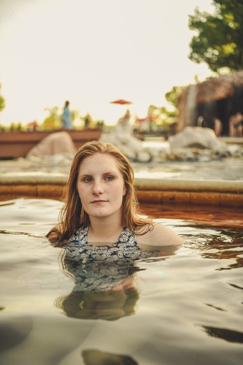 女人在游泳池里游泳的照片 · 免费素材图片