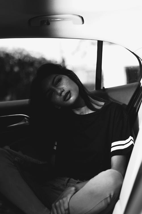 女人坐在车里的单色照片 · 免费素材图片
