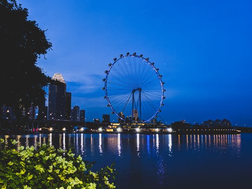 夜间摩天轮在水体附近 · 免费素材图片