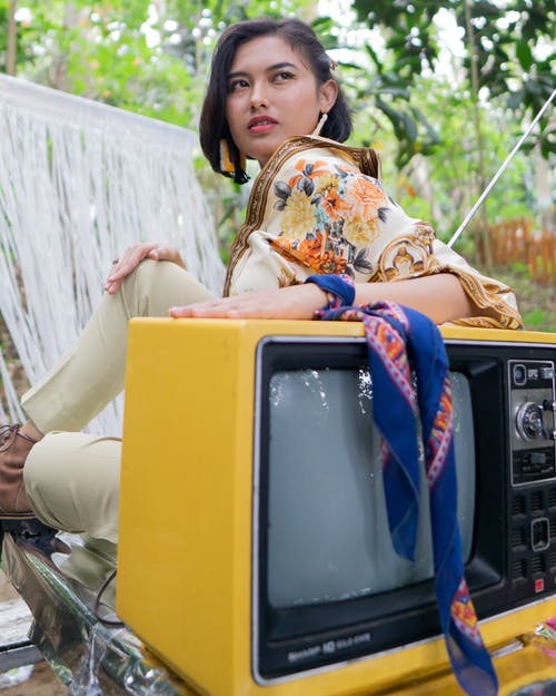 靠在电视上的女人的照片 · 免费素材图片