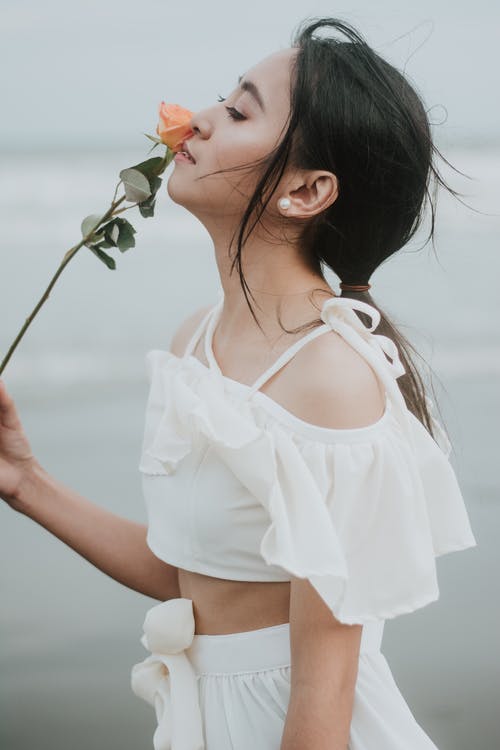 女人嗅花的照片 · 免费素材图片