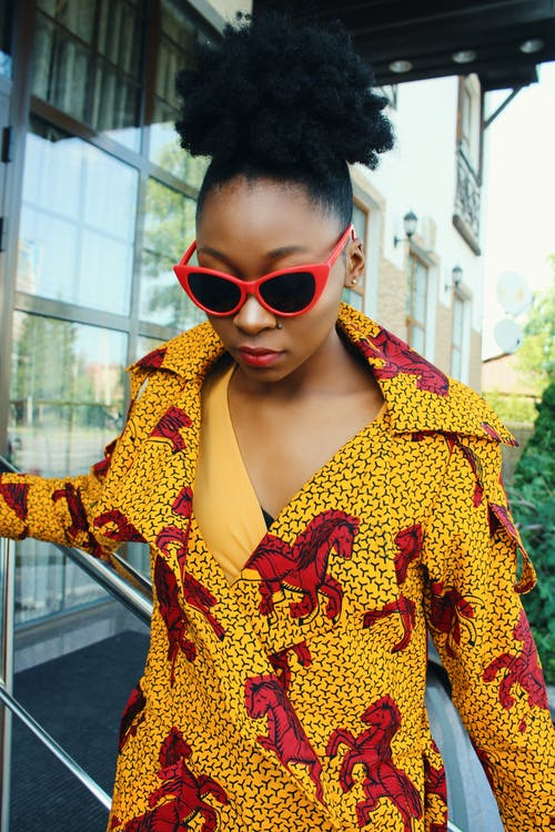 女人站在灰色不锈钢栏杆附近往下看 · 免费素材图片