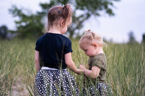 两个女孩站在草地上 · 免费素材图片