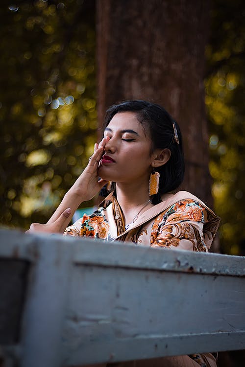 女人坐在长椅上的照片 · 免费素材图片