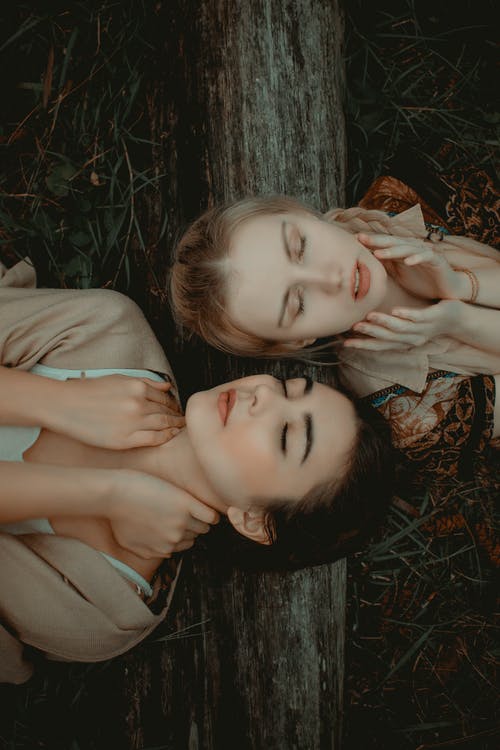两名女子躺在草地上的照片 · 免费素材图片