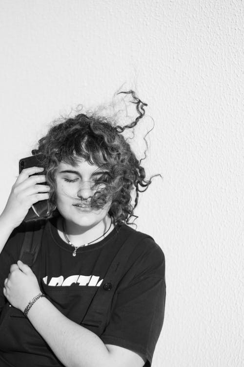 女人拿着智能手机的单色照片 · 免费素材图片