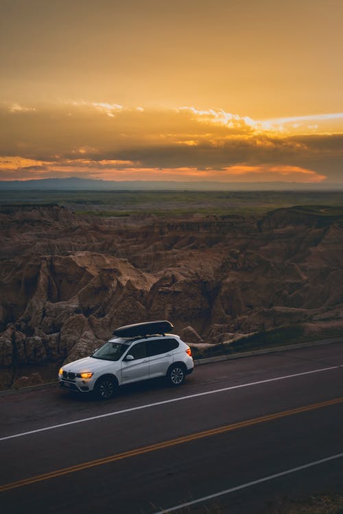 日落期间山地形附近的路边的车 · 免费素材图片