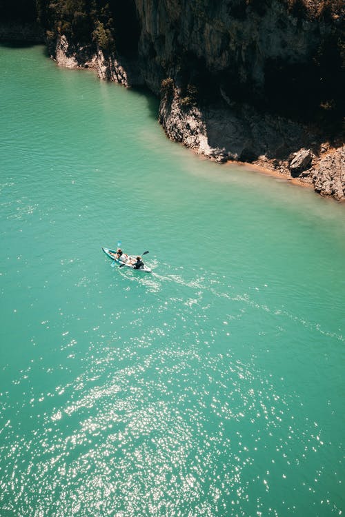 两人在水体中骑独木舟 · 免费素材图片