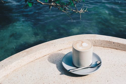 水体附近的咖啡杯照片 · 免费素材图片