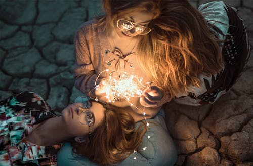 两名女子带灯串的高角度照片 · 免费素材图片