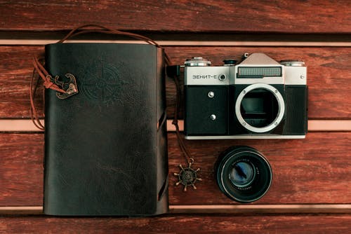 静物摄影黑色和银色单反相机和黑色变焦镜头 · 免费素材图片