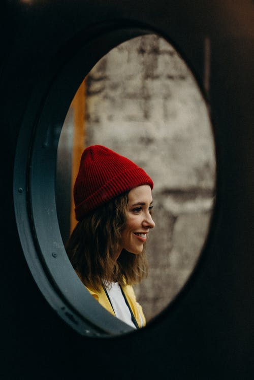 微笑的女士戴着红色的针织帽 · 免费素材图片