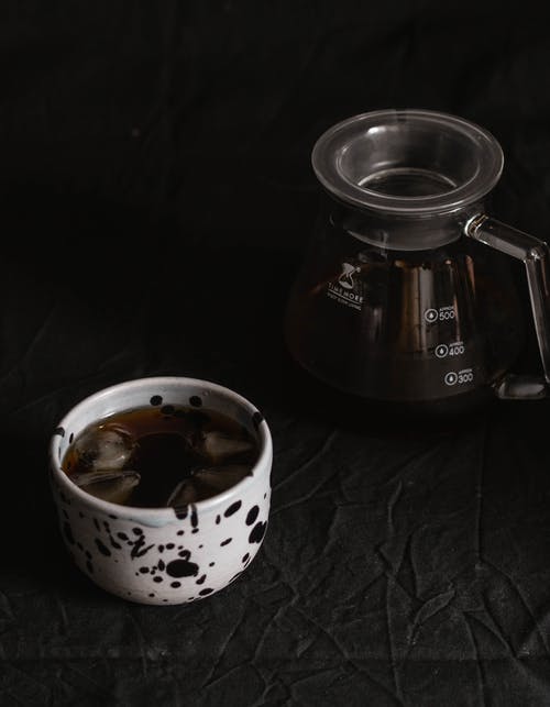 杯黑咖啡，在桌子上的玻璃水瓶旁边的冰 · 免费素材图片