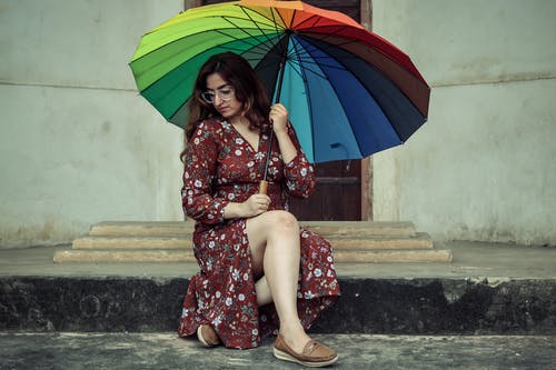 女人拿着五颜六色的雨伞的照片 · 免费素材图片