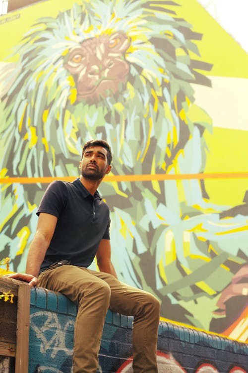 男子坐在混凝土平台上的照片 · 免费素材图片