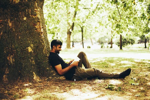 男子坐在地上对树 · 免费素材图片
