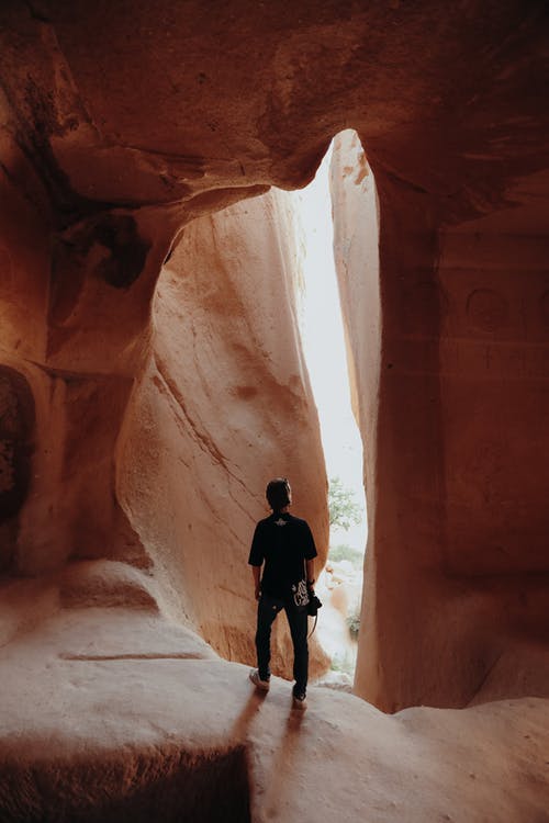站在峡谷岩石内的人的照片 · 免费素材图片