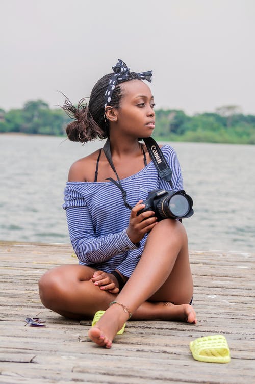 拿着照相机的妇女坐的照片 · 免费素材图片