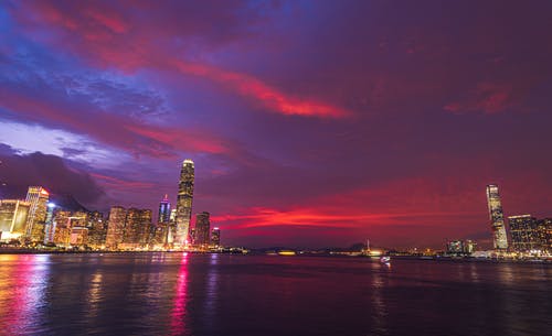 海洋附近夜间的高层建筑 · 免费素材图片