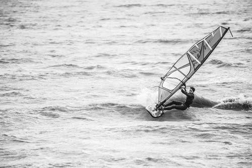 人骑帆船冲浪的灰度摄影 · 免费素材图片