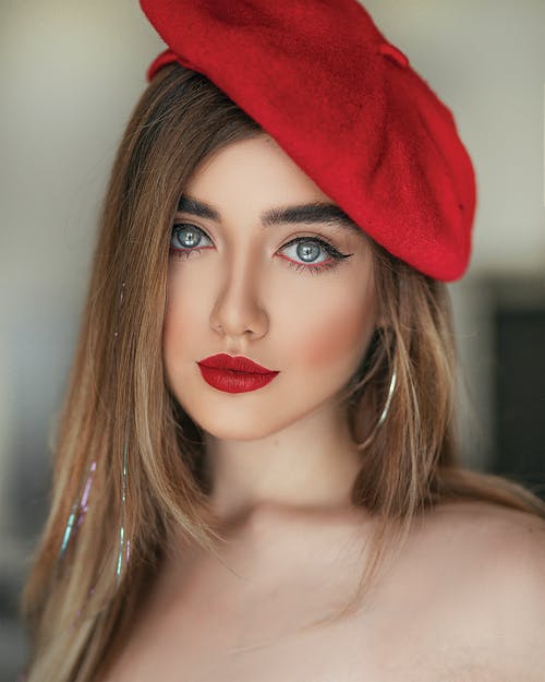 女人在红色的唇膏和红色贝雷帽帽子摆姿势的肖像照片 · 免费素材图片