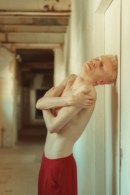 裸照穿着红色短裤倚在白墙上的男人 · 免费素材图片