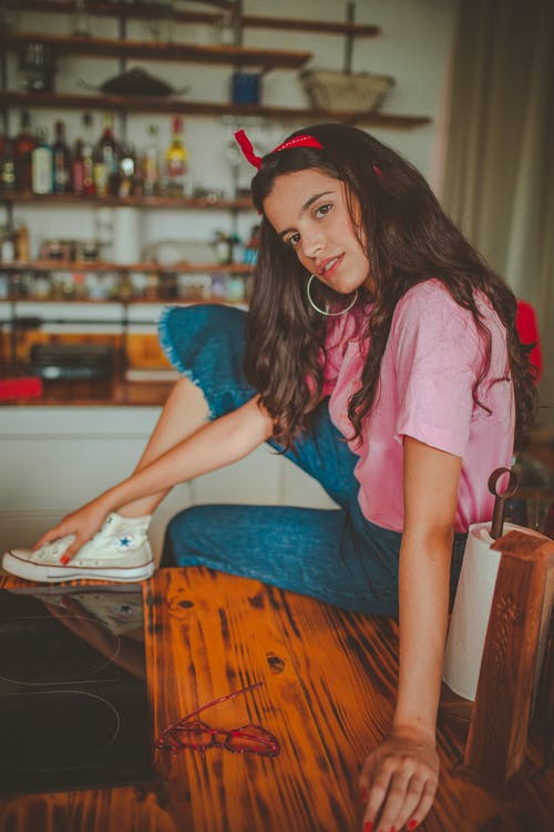 女人坐在木桌上的照片 · 免费素材图片