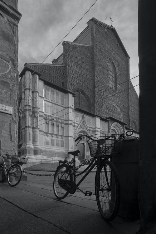 大教堂旁边停放的自行车的灰度摄影 · 免费素材图片