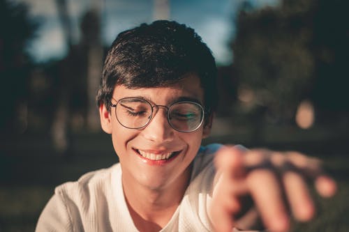 戴黑框眼镜的男人微笑着的选择性聚焦摄影 · 免费素材图片