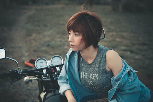 女人靠在摩托车上的照片 · 免费素材图片