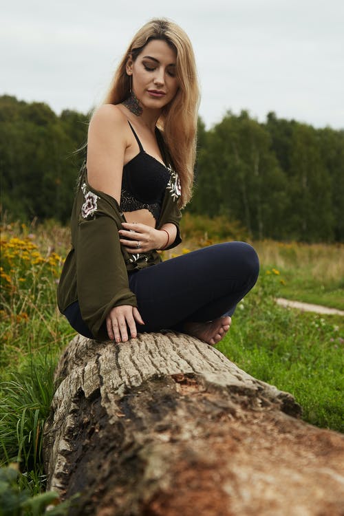 女人坐在木原木上的照片 · 免费素材图片