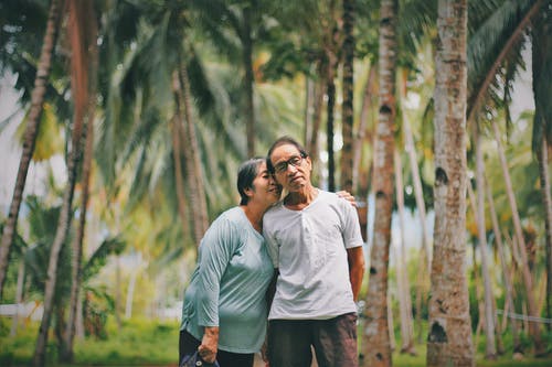 老夫妇与背景一起站立的选择聚焦照片 · 免费素材图片
