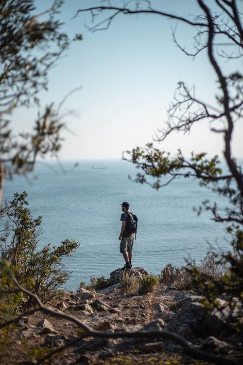 男子站在悬崖附近的岩石上 · 免费素材图片