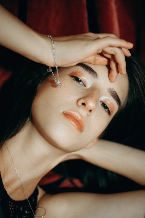 黑色上衣和珠宝抚摸她的额头上的女人 · 免费素材图片