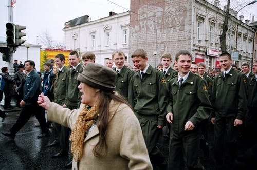 站在道路上的军事人员面前的女人 · 免费素材图片