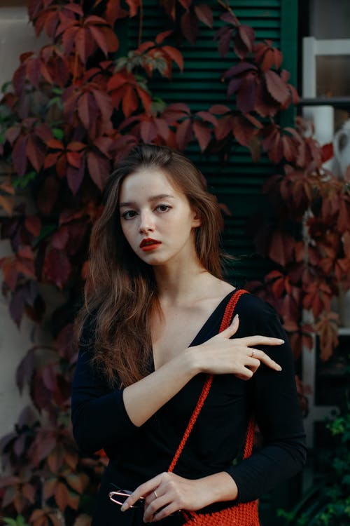 站在灌木丛旁边的女人的照片 · 免费素材图片