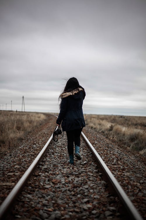 在铁路中间行走的女人 · 免费素材图片
