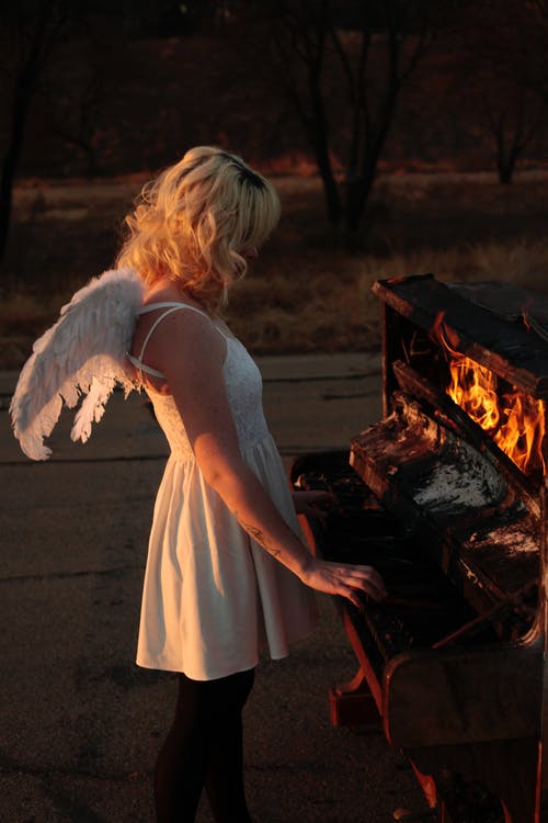 在燃烧的钢琴上玩的女人 · 免费素材图片